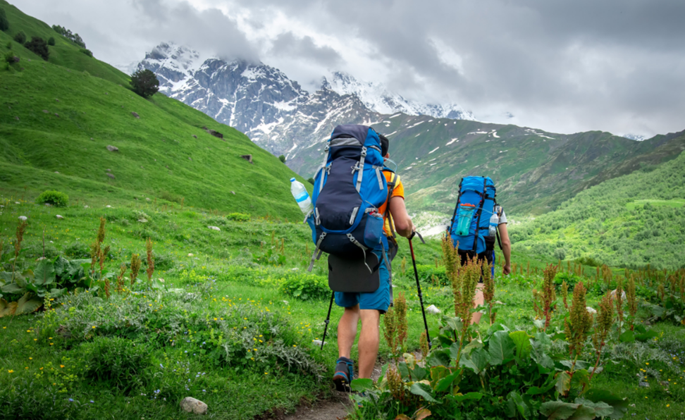 Two people with large backpacks hiking in the mountains